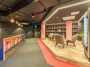 A modern interior with a bar area, seating, and a bookshelf. - Student Only Crown House (Brighton and Hove)