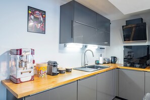 Een moderne keuken met een ingebouwde magnetron, een koffiezetapparaat, een popcornmachine en een spoelbak met een kraan.