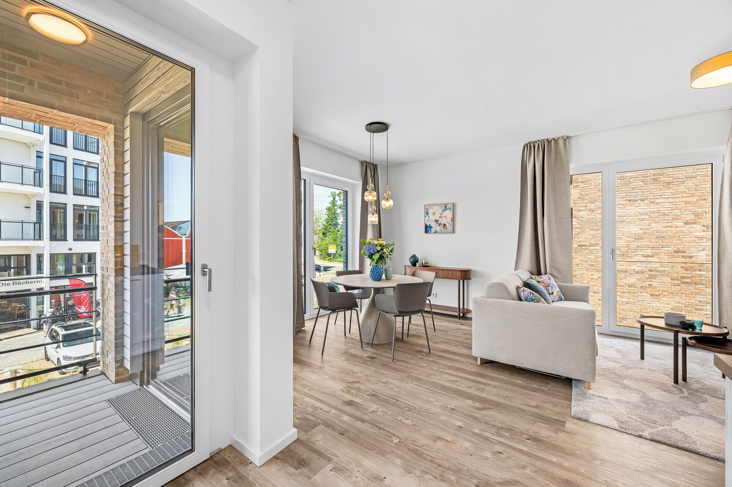 A modern apartment with a dining area, a sofa, and a view of the city.
