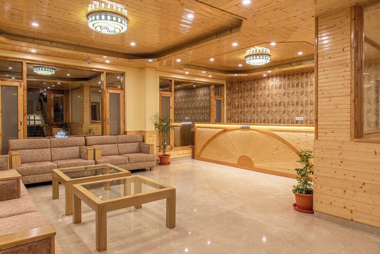 Un vestíbulo de hotel con mostrador de recepción, sofás y una mesa de centro.