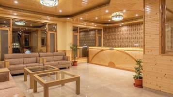Un vestíbulo de hotel con mostrador de recepción, sofás y una mesa de centro.