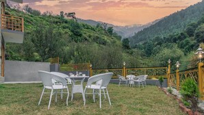 Una terraza con mobiliario exterior y vistas a un paisaje montañoso.