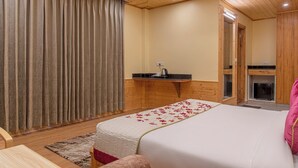 Ein Schlafzimmer mit Bett, Schreibtisch, Spiegel und Kamin.