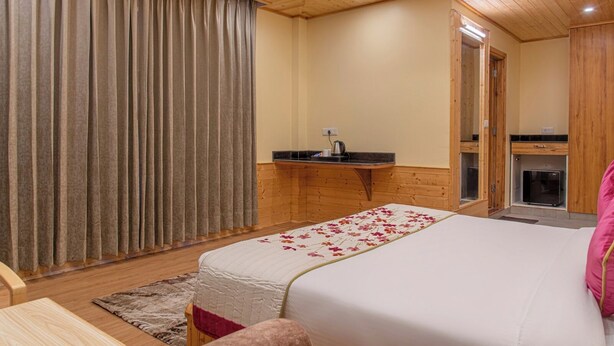 Un dormitorio con cama, escritorio, espejo y chimenea.