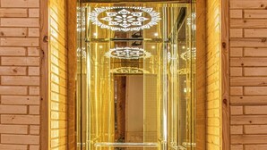 Una entrada de madera con marco y puerta de cristal, adornada con diseños elaborados.
