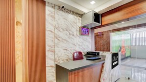 A reception desk with a marble wall, a wooden panel, a security camera, and a framed picture. - Super Collection O AIIMS Bhubaneshwar (Bhubaneshwar)