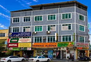 A multi-story commercial building with various storefronts, including a car dealership and a beauty salon. - Hotel O HR Inn Resthouse Services (Kuala Krai)