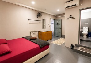 A hotel room with a bed, a dresser, a mirror, a door, and a bathroom. - Hotel O HR Inn Resthouse Services (Kuala Krai)