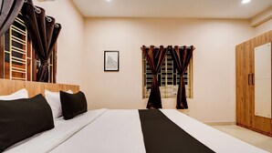 A hotel room with a large bed, a wardrobe, a window with curtains, and a framed picture on the wall. - Collection O Ravi Talkies Bhubaneswar (Bhubaneshwar)