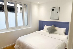 A bedroom with a bed, a window, and a wall-mounted certificate. - celine 16 (Paris)