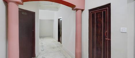 A corridor with a pink archway, a door labeled '104', and a dark wooden door.