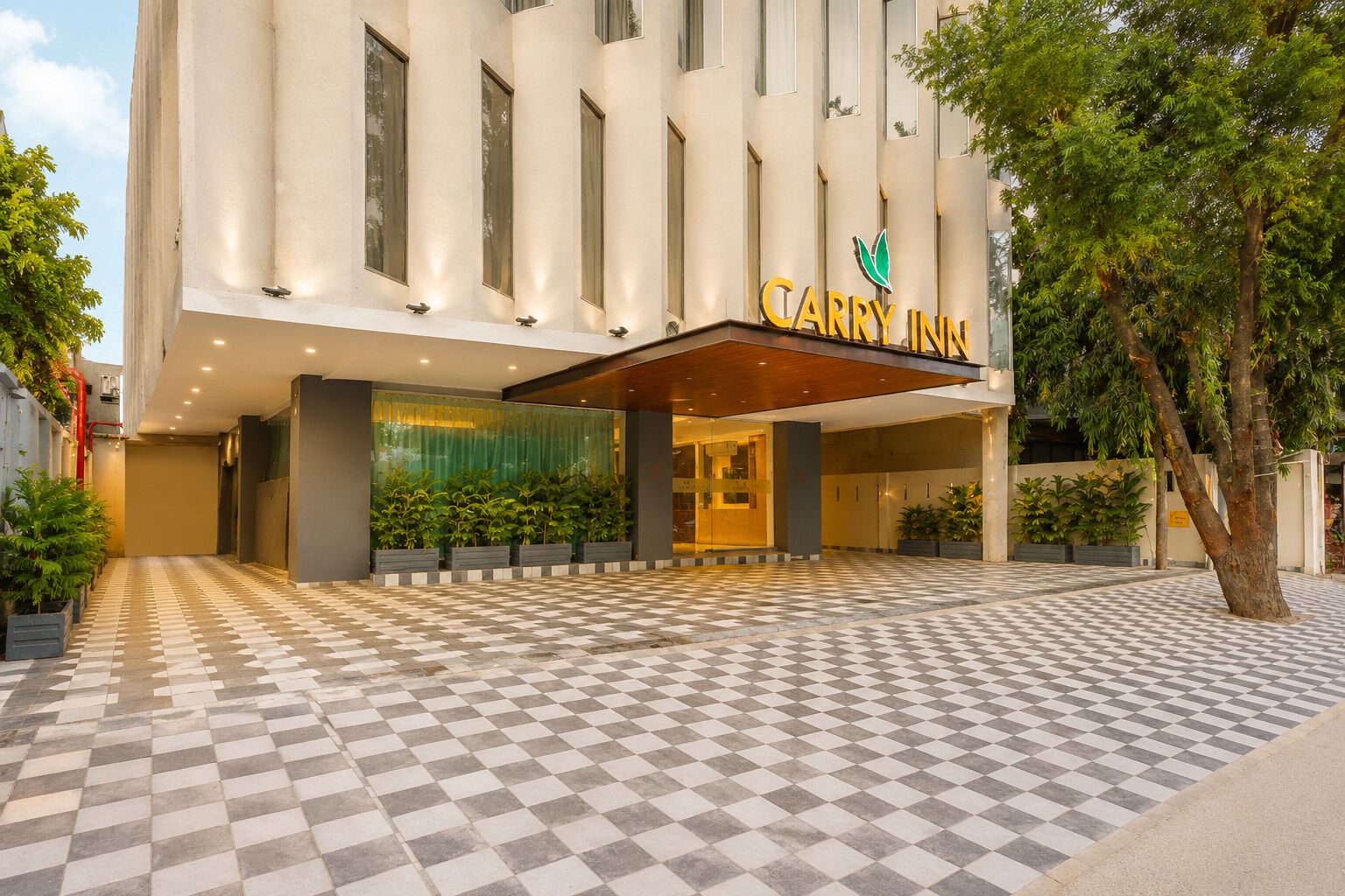 A hotel entrance with a checkered floor, a large entrance canopy, and a sign reading 'CARRY INN'.