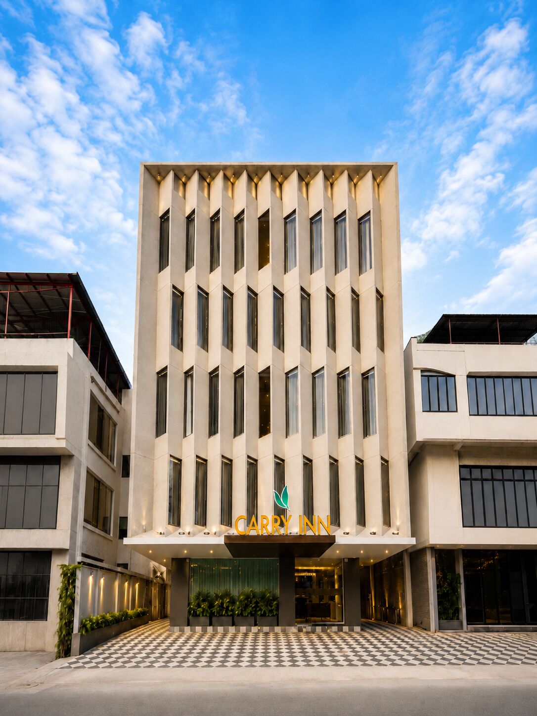 A modern building with a flat facade, multiple windows, and a checkered entrance area.