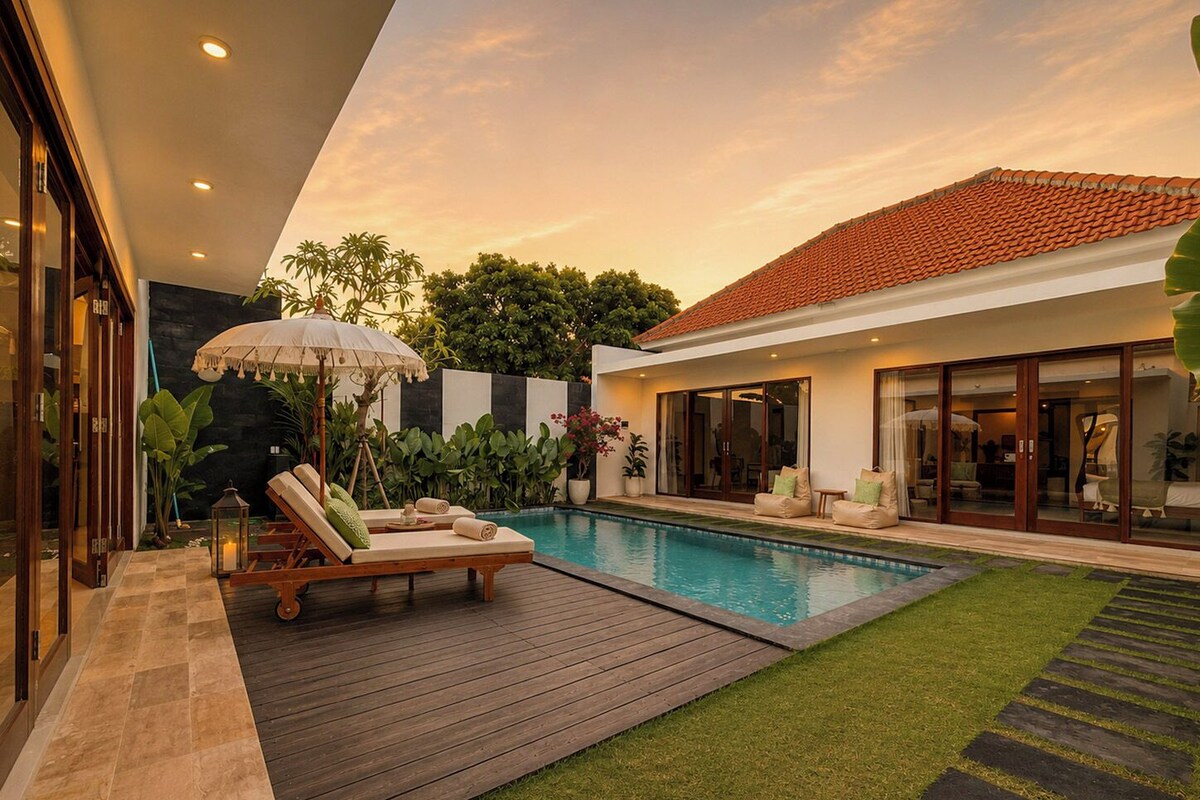 A modern house with a swimming pool, a wooden deck, and a well-maintained lawn.