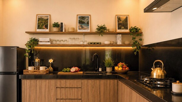 Una cocina moderna con encimera negra, armarios de madera, refrigerador de acero inoxidable, estufa a gas y un lavaplatos.