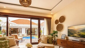 Amplia sala de estar con piscina, asientos cómodos y televisión.