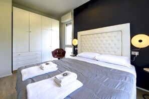 A modern hotel room with a large bed, a wardrobe, and a chair. - MGH - Salò Urban Retreat (Salò)