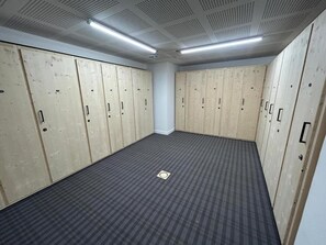 A room with wooden lockers, a checkered floor, and a ceiling with a grid pattern. - Apartment for 8 people - 2 garages - Exceptional view (Huez)