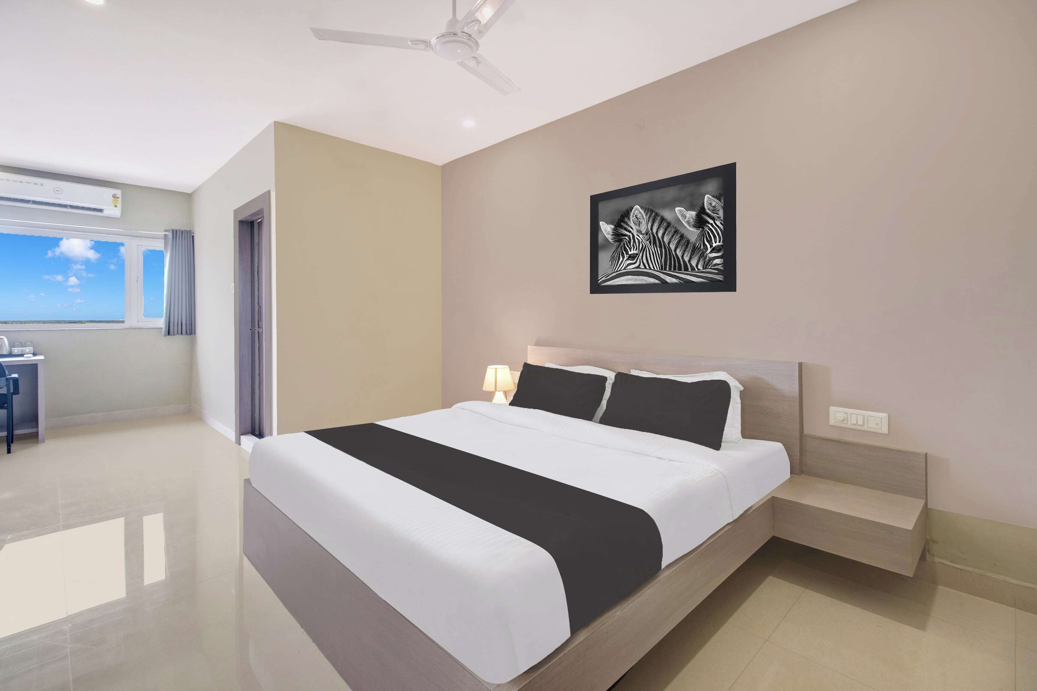 Ein modernes Schlafzimmer mit Bett, Nachttisch und Deckenventilator.