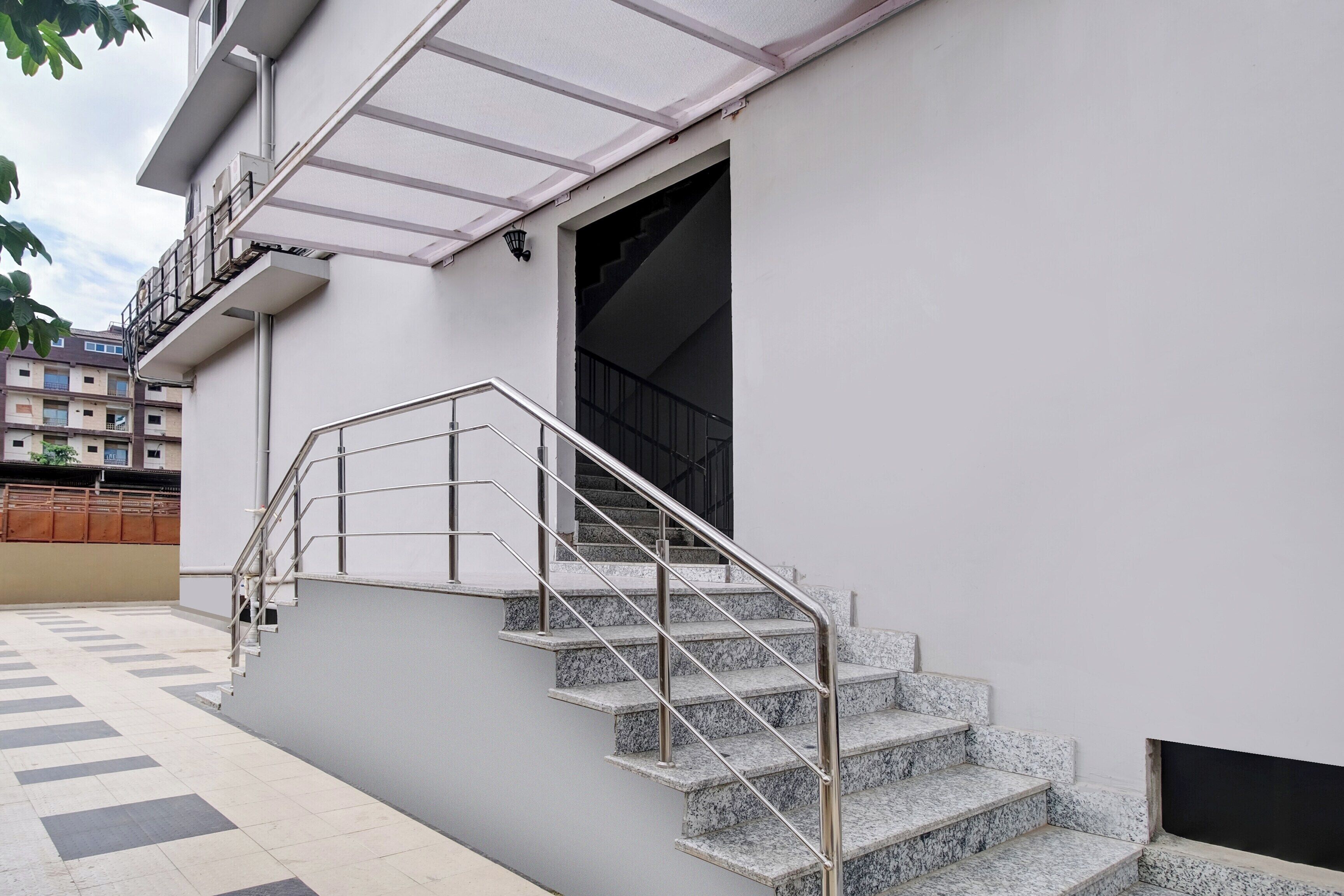 Ein Gebäude mit einer Treppe, einem Metallgeländer und einem gefliesten Boden.