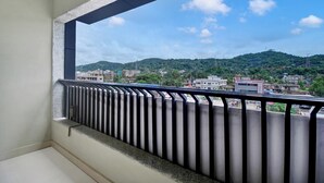 A balcony with a metal railing overlooking a cityscape with buildings and hills. - Super Collection O Guwahati ISBT (Guwahati)