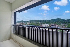 A balcony with a metal railing overlooking a cityscape with buildings and hills. - Super Collection O Guwahati ISBT (Guwahati)
