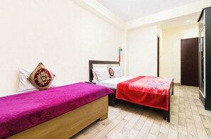 Ein Zimmer mit zwei Betten, einem Kleiderschrank und einer Tür.