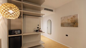 Un interior moderno con una lámpara colgante, un televisor de pantalla plana, una máquina de café y un cuadro en la pared.