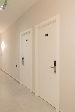 A hallway with three doors, each marked with a number. - Aulona Central Rooms (Vlorë)