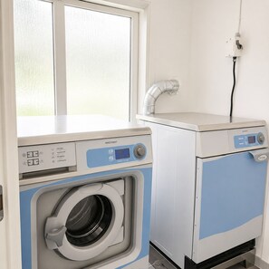 A compact laundry room with a front-loading washing machine and a stacked dryer.