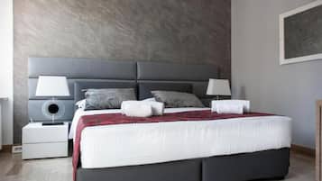 Un dormitorio moderno con una cama grande, dos mesitas de noche y un cabecero.