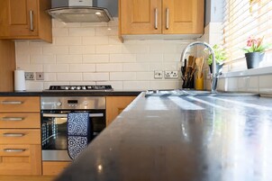 Una cocina moderna con armarios de madera, una estufa de acero inoxidable y una isla grande con un lavamanos.