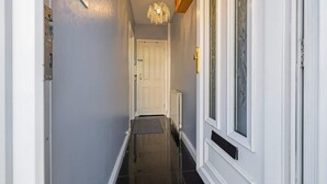 A hallway with a white door, a radiator, and a textured wall.