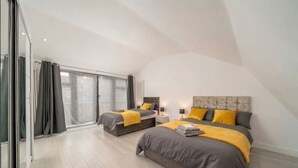 A modern bedroom with two beds, a large window, and a sliding door. - Comfy 3BR House Near Tottenham Stadium Parking (London)
