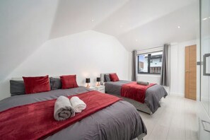 A modern bedroom with two beds, a large window, and a view of the outside. - Comfy 3BR House Near Tottenham Stadium Parking (London)