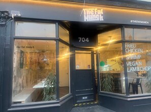 Ein Restaurant namens 'The Fat Munch' mit schwarzem Fassadenbau und großen Fenstern.