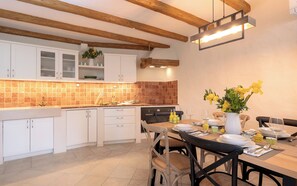 A modern kitchen with white cabinets, a tiled backsplash, and exposed wooden beams. - Villa Hedera - beautiful stone house on Hvar (Dol)