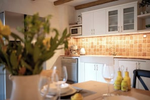 A modern kitchen with white cabinets, a microwave, and a coffee machine. - Villa Hedera - beautiful stone house on Hvar (Dol)