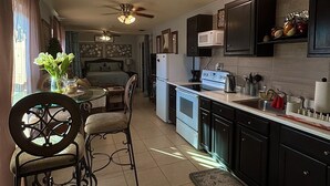 Una cocina con comedor, ventilador de techo y microondas.