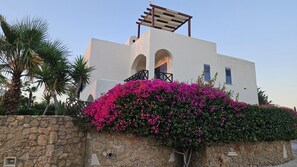 A building with a stone wall, a balcony, and pink flowers. - 126 PAP - Stay Villa Nefeli (Chlorakas)