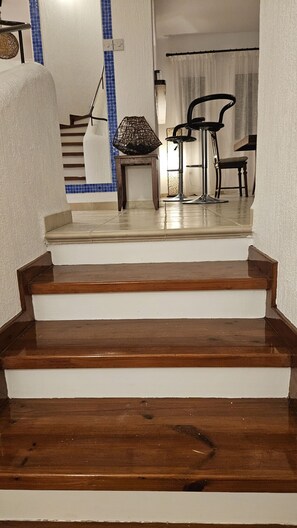 Eine Treppe mit Holzboden, die zu einem Raum mit Essbereich führt.
