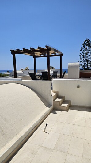 A rooftop terrace with a pergola, outdoor seating, and a view of the sea. - 126 PAP - Stay Villa Nefeli (Chlorakas)