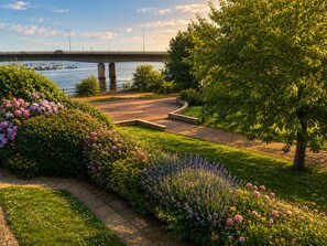 Ein angelegter Garten mit einem Pfad, der zu einer Brücke über dem Wasser führt.