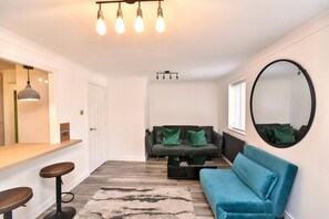 Ein modernes Wohnzimmer mit einer Couch, einem Couchtisch und einem runden Spiegel an der Wand.
