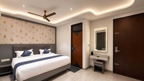A modern bedroom with a bed, bedside table, nightstand, and a ceiling fan.
