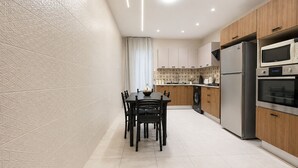 Cocina moderna con comedor, que incluye horno empotrado, microondas y lavadora.