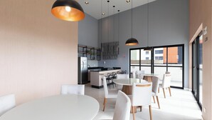 A modern interior with a dining area, kitchen, and large windows. - Studio in a Cond. With a gym in Downtown Muv0811 (Curitiba)