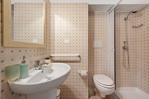 A bathroom with a sink, toilet, and shower.