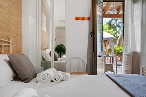 A hotel room with a bed, a chair, a table, and a view of the outside. - Oceana – Spacious Quadruple Room at Marea Blanca (Porto Cesareo)