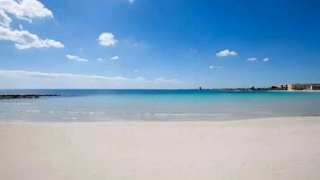 Ein Strand mit blauem Himmel und ruhigem Wasser.